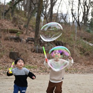大きなしゃぼん玉をつぶして遊んでいます。