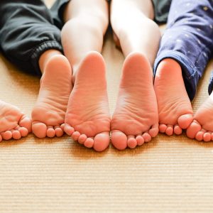 畳の上に、3人の子供たちが並んでうつ伏せに寝転んでいる微笑ましい日常。