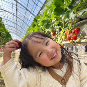 いちご狩りで自分で撮った苺を食べて嬉しそうな写真