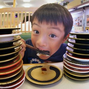 孫は寿司特にのりを巻いたものが大好きです。同席の家族の協力もあり、回転寿司の皿が高く積み上げらました。孫は、幸せそうに海苔巻きをさらに食べました。